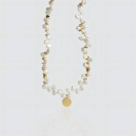 Artisanal Craftsmanship. A crisp look at the interplay between shimmering pearls and the vintage-inspired gold coin.