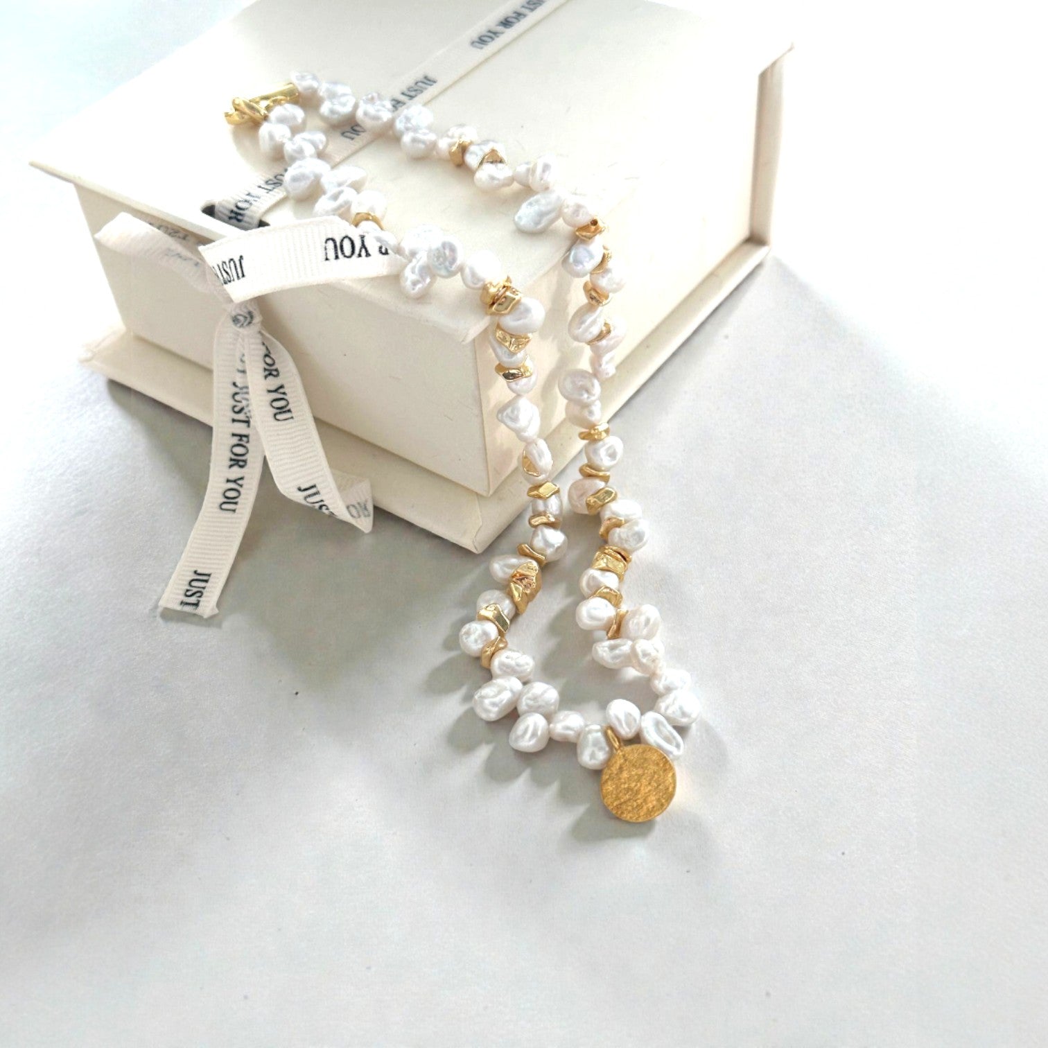 Golden Accents. Highlighting the hammered texture of the coin and the individual character of each baroque pearl.