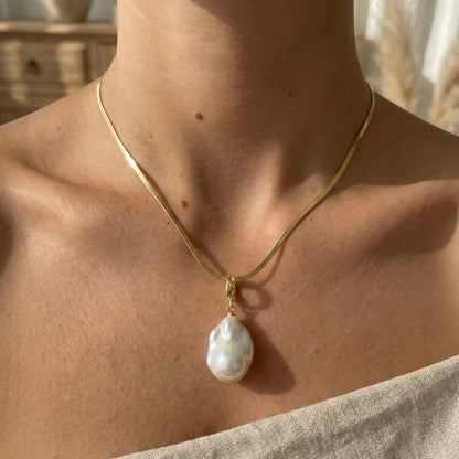 A model wearing the gold vintage flat chain necklace, showing how the herringbone style lays flat against the collarbone.