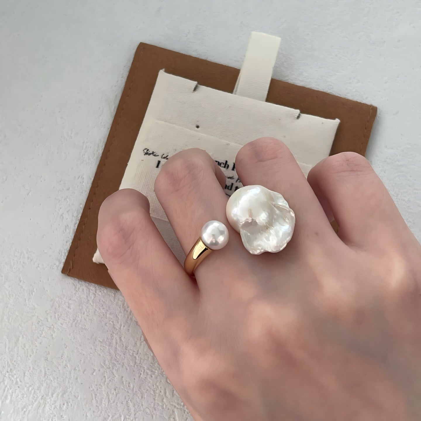 Styling a chunky baroque pearl ring with a minimalist outfit for a modern look.