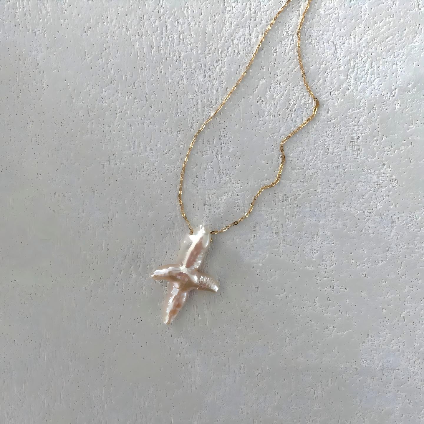 Close-up detail showing the iridescent luster and natural texture of the irregular baroque pearl pendant.