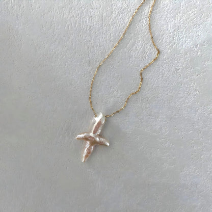 Close-up detail showing the iridescent luster and natural texture of the irregular baroque pearl pendant.