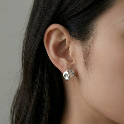 Modern Radiance. Seen worn, these studs add a contemporary artistic touch to any look, perfectly catching the light with every movement.