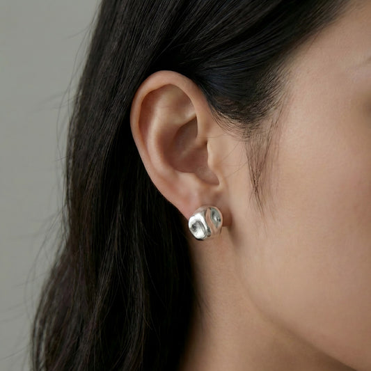 Modern Radiance. Seen worn, these studs add a contemporary artistic touch to any look, perfectly catching the light with every movement.