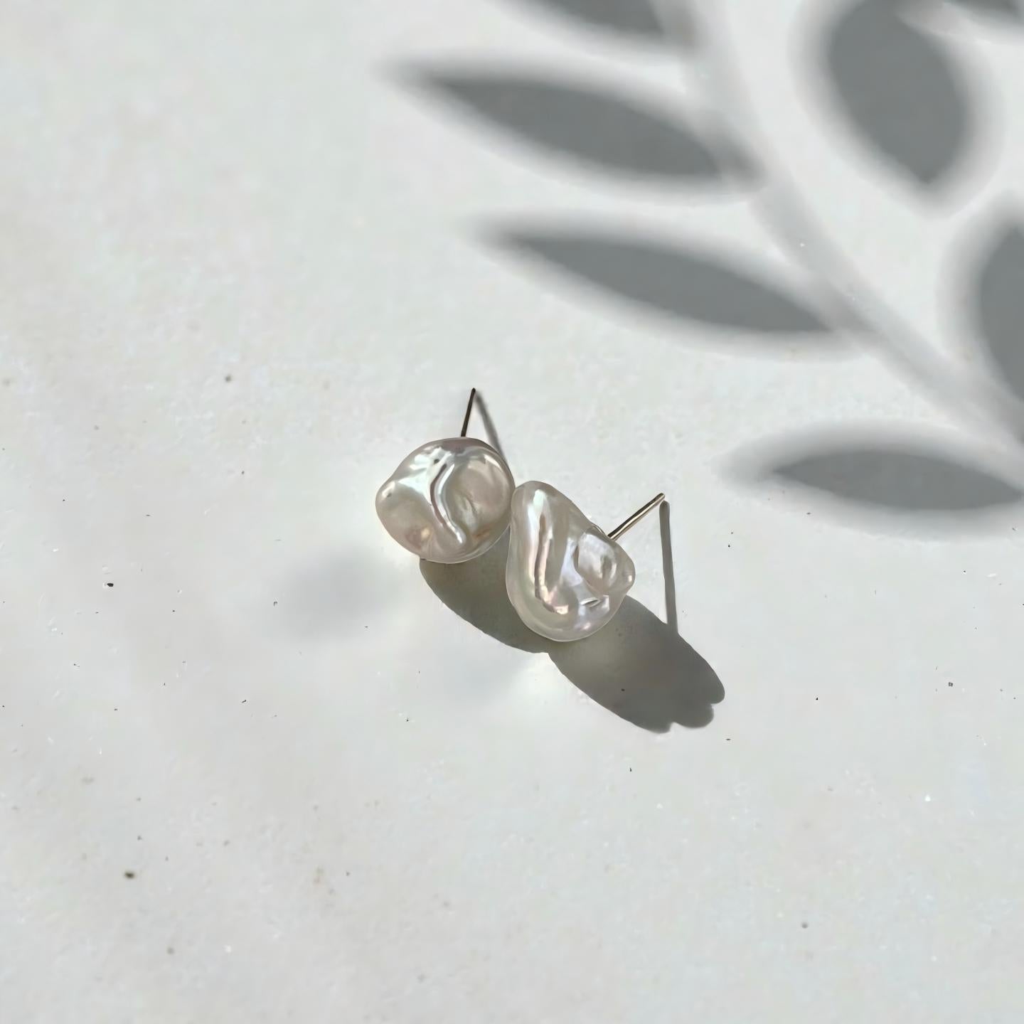 Nature’s Fingerprint. A macro shot highlighting the unique ripples and "crinkle" texture of our solid nacre baroque pearls. Truly one-of-a-kind.