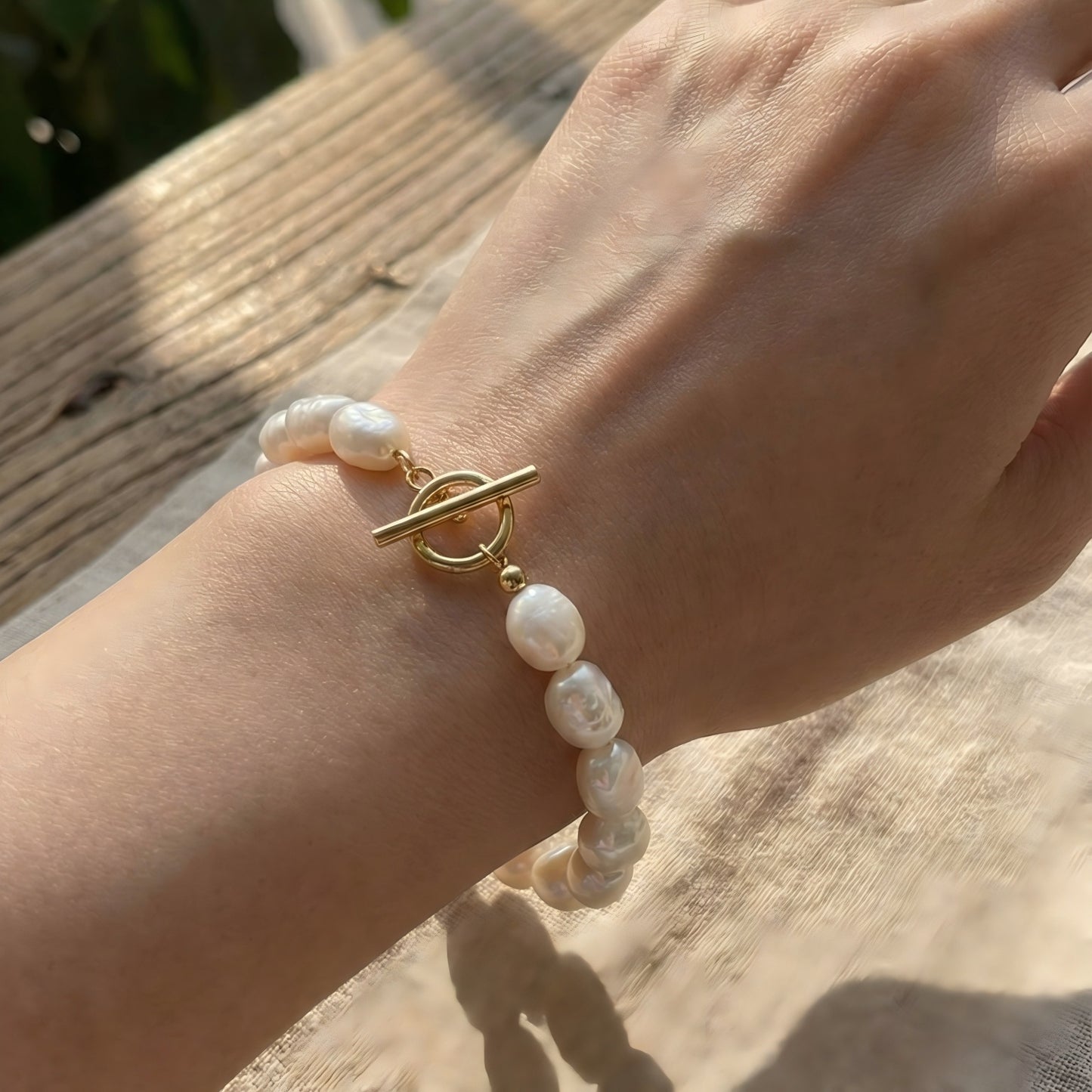 Captured in the golden hour. See how the pearls glow against the skin, with the gold toggle clasp adding a focal point of modern sophistication.