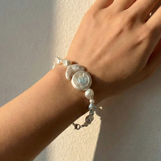 Styled solo to highlight its architectural design. The cool silver tones and bright white pearls add a sharp, artistic touch to a sleek, modern look.