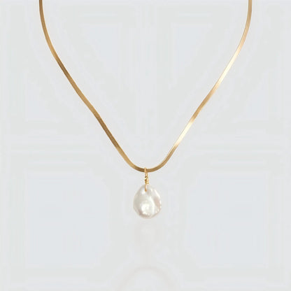 A flat gold snake chain necklace featuring a single white baroque pearl pendant isolated on a light background. The necklace has a sleek, herringbone texture that resembles liquid gold. Minimalist pearl jewelry by Pearltide.