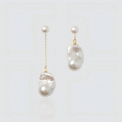 Pair of asymmetrical freshwater pearl earrings on a white background. Left earring features a long gold chain drop, while the right earring is a short drop, both with round pearl studs.