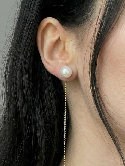 Mujer luciendo unos pendientes de hilo con la perla ajustada al lóbulo y la cadena fina colgando, estética clean look.