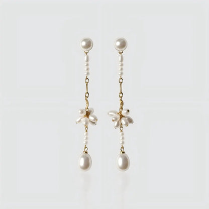 A pair of long gold-plated drop earrings by Pearltide against a plain white background.
