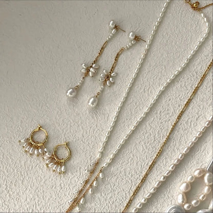 A detailed macro shot focusing on the center section of the Pearltide earring. It highlights the intricate craftsmanship of the floral cluster, hand-woven from small, oval freshwater pearls held by delicate gold wirework.