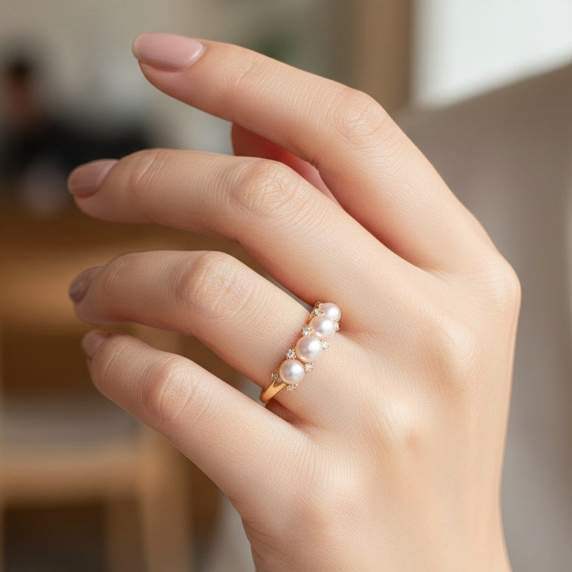 Elegant pink pearl cluster ring worn on a woman’s hand, showcasing the delicate scale and soft luster against a lifestyle background.