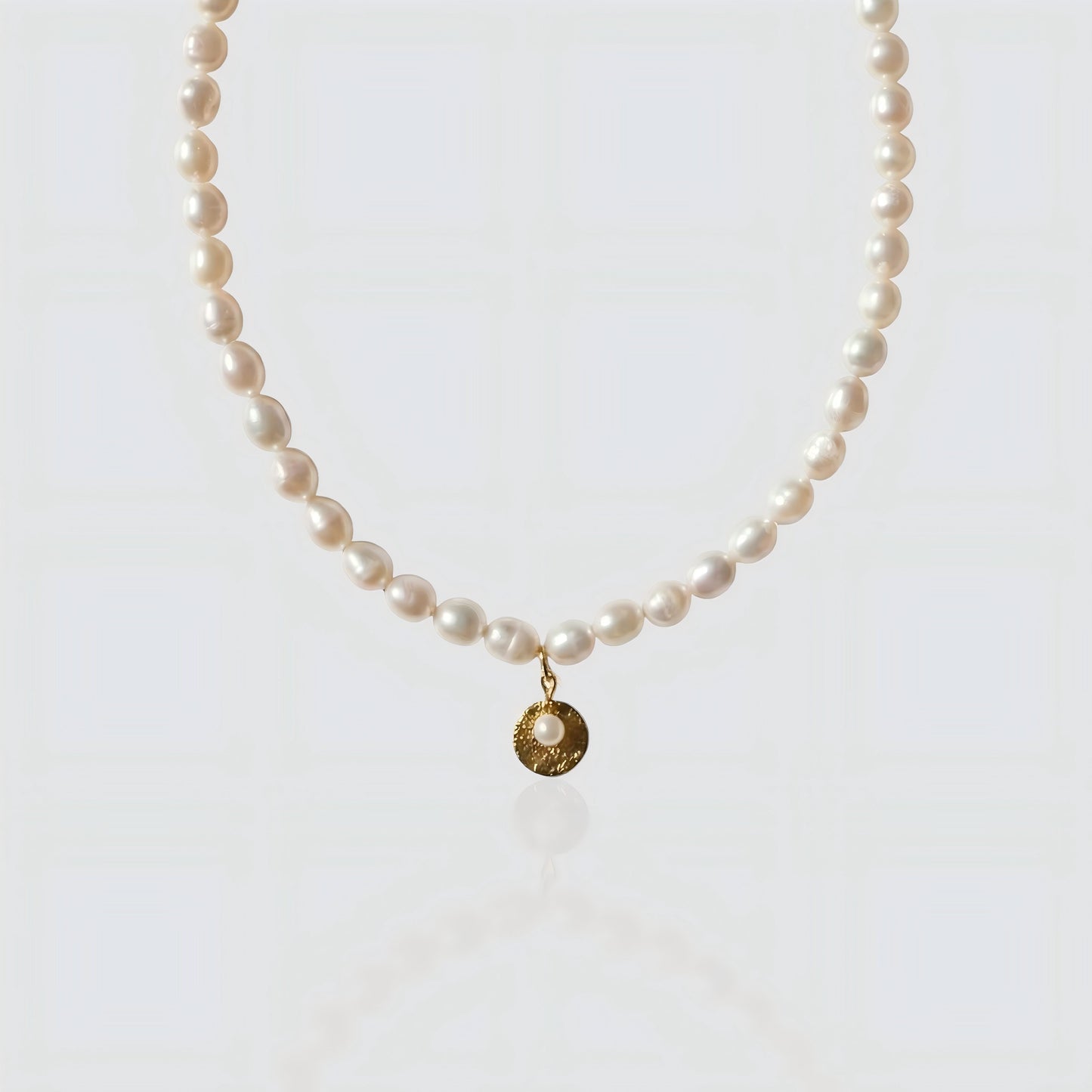 Full strand freshwater pearl necklace featuring a textured gold coin pendant with a small pearl center. Vintage-inspired jewelry by Pearltide on white background.