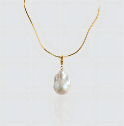 A full view of the Vintage Flat Chain necklace, featuring a sleek gold herringbone chain holding a unique baroque pearl pendant.