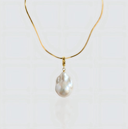 A full view of the Vintage Flat Chain necklace, featuring a sleek gold herringbone chain holding a unique baroque pearl pendant.