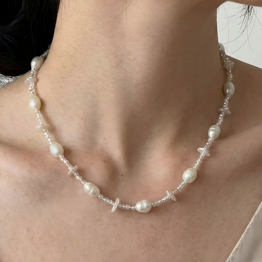 A young woman wearing the mixed pearl and seed bead necklace, looking fresh and summery.