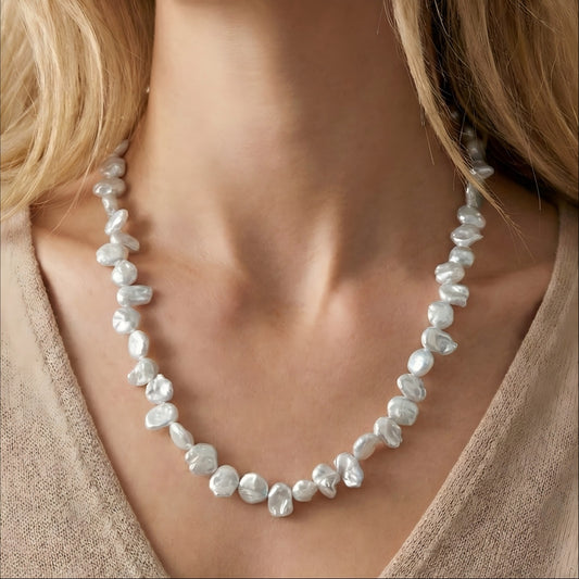 A model wearing the organic Keshi pearl necklace, highlighting the petal-like texture and shine against the skin.